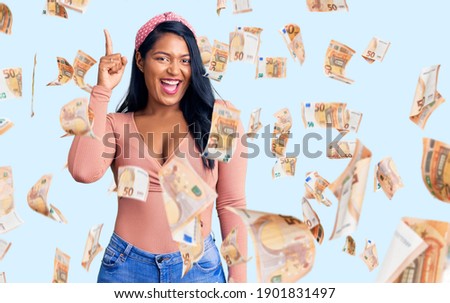 Hispanic woman with long hair wearing casual clothes pointing finger up with successful idea. exited and happy. number one.