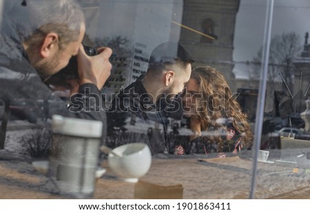 the photographer shoots a beautiful and happy couple in a cafe