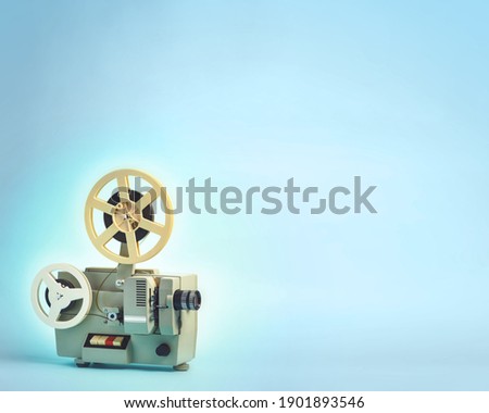 Old cinema projector on blue background