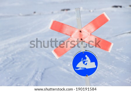 Snow-scooter and winter trail sign in the snow in Sweden.