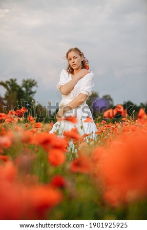 portrait of a girl in a field of poppies