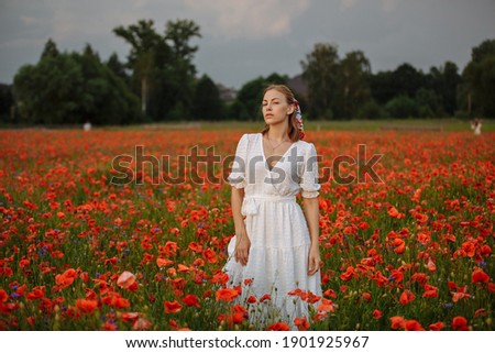 woman in white dress in a field of poppies