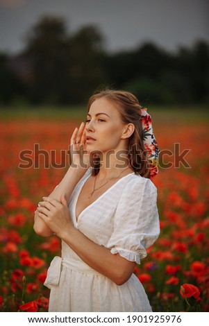 woman in white dress in a field of poppies
