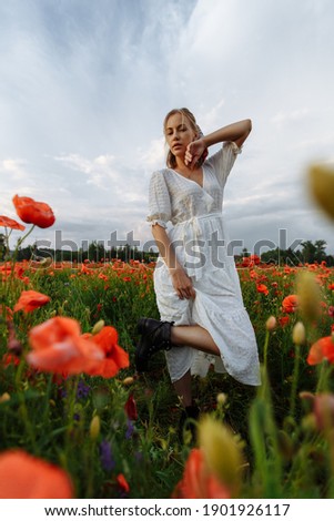 portrait of a girl in a white dress and black shoes in a field of flowers