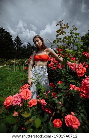 girl posing in the garden of red roses