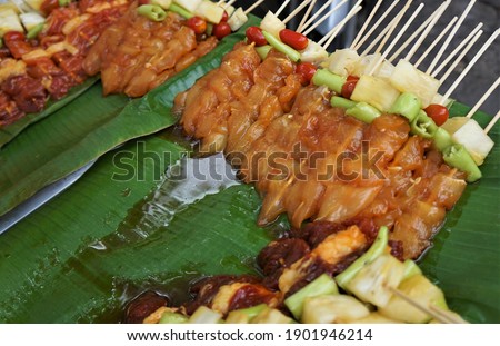 Bulk raw barbecues are stacked on banana leaves. It's at the street food store.