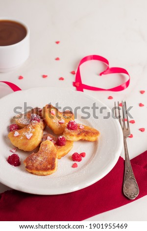 Valentines day breakfast. Delicious cheesecakes in the shape of hearts with coffe americano with milk. Top view. Love concept. 