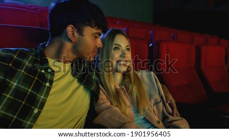 Portrait of charming couple, attractive young man and woman watching film together, having romantic movie date at the cinema. Relationship, entertainment concept. Web Banner
