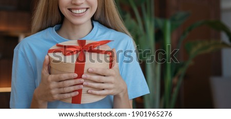 Cropped image of beautiful smiling woman holding gift boxes. Portrait of young emotional girl with birthday presents in hands, copy space	
