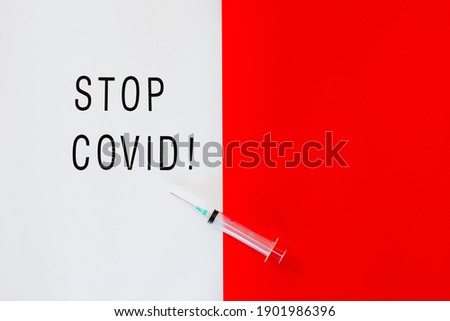 Creative design for Coronavirus vaccine background. Top view of syringe laying on white and red background with copy space.