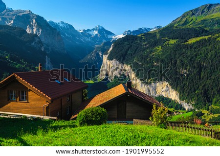Cozy wooden lodges with amazing views from the Wengen mountain resort. Lauterbrunnen valley and mountains with glaciers in background, Bernese Oberland, Switzerland, Europe Royalty-Free Stock Photo #1901995552