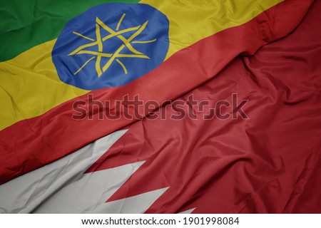 waving colorful flag of bahrain and national flag of ethiopia . macro