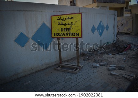Deep Excavation signboard on construction site in English and Arabic