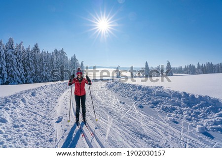beatiful active senior woman cross-country skiing in fresh fallen powder snow in the Allgau alps near Immenstadt, Bavaria, Germany Royalty-Free Stock Photo #1902030157