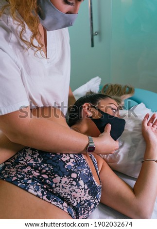 Young female physiotherapist adjusting patients neck in contemporary clinic. Physiotherapy, rehabilitation concept. 