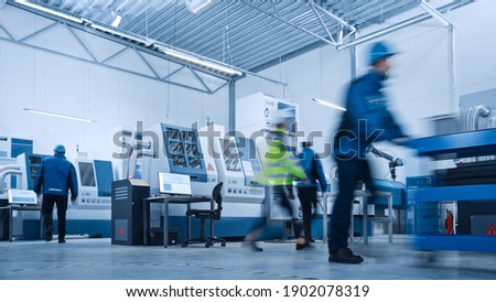 Indusry 4.0 Factory: Blurred Motion Shot of a Team of Engineers, Professionals and Workers, Working on Assembly and Production Line, Optimizing CNC Machinery, Programming Machines. Royalty-Free Stock Photo #1902078319