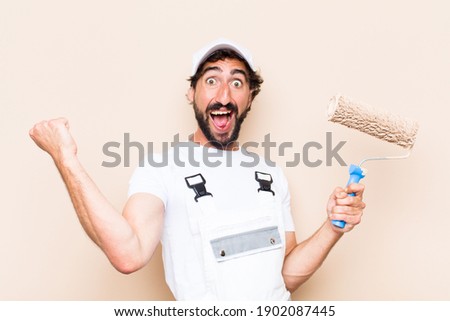 young painter bearded man celebrating his success and holding a 