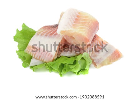 Pangasius fish fillet, pieces on a green lettuce leaf. Isolated on a white background. Fresh Fish Fillet.