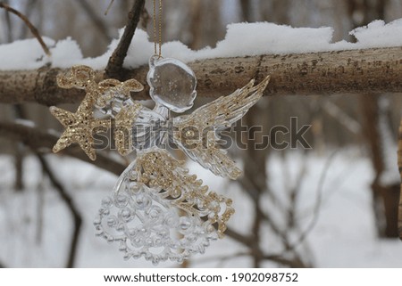 Christmas Angel in the forest on the winter tree with snow in winter time. Magic atmosphere in xmas nature.