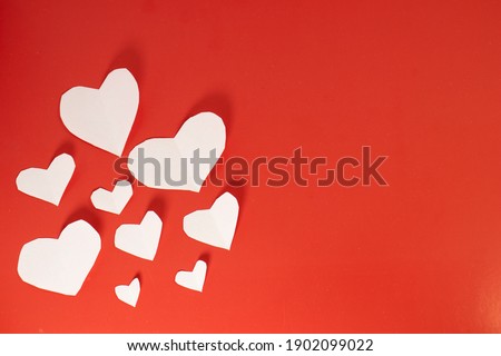 white paper hearts on red isolated background. valentine's day cards with copy space