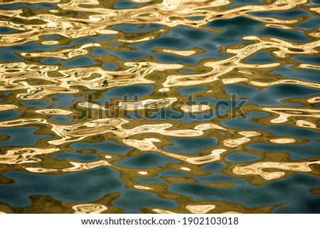 Sunshine golden reflections on clear water.