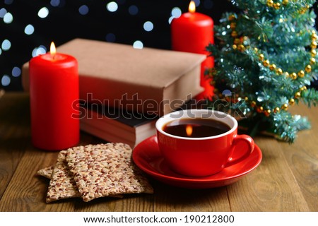 Composition of book with cup of coffee and Christmas decorations on table on dark background