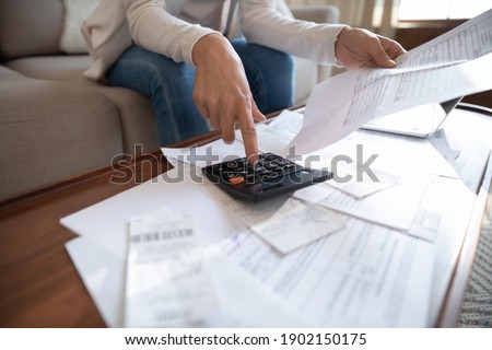 Close up busy woman using calculator, renter checking bills, planning budget, sitting at desk with financial documents and receipts, accounting expenses, calculating money, rent or mortgage payment Royalty-Free Stock Photo #1902150175