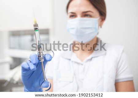 Selective focus on the syringe female doctor is holding