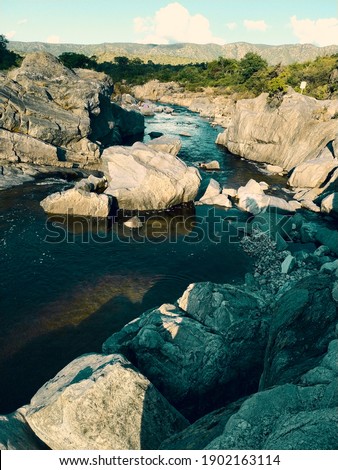 PHOTOGRAPH OF A RIVER AMONG THE ROCKS IN CORDOBA ARGENTINA