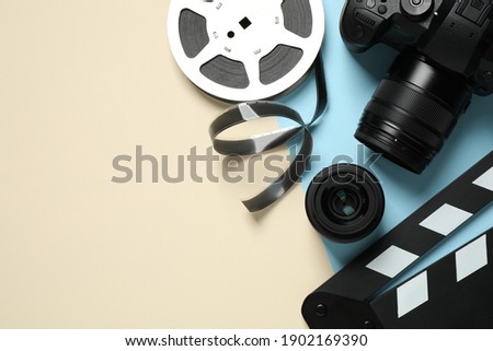 Flat lay composition with camera and video production equipment on color background. Space for text