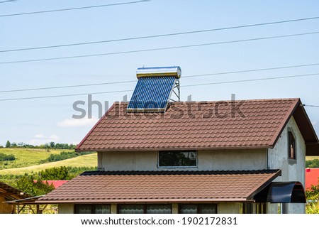Solar water heater on roof top. Solar panel for hot water, system on roof. Royalty-Free Stock Photo #1902172831