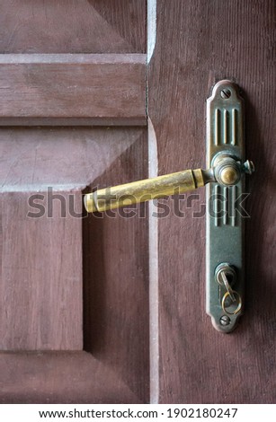 Wooden vintage brown lacquered doors with metal rustic door handle and the key Royalty-Free Stock Photo #1902180247