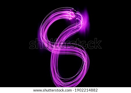 Long exposure photography. Writes 8 with pink light on black background. Neon lights wallpaper.