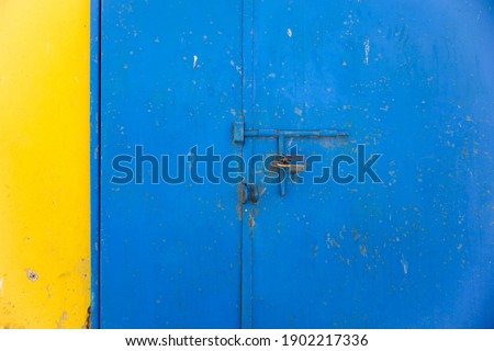 close up of a yellow wall and blue door with lock on it, grunge style