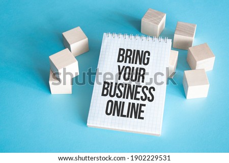 Text BRING YOUR BUSINESS ONLINE on white notepad with cube block, stock concept.