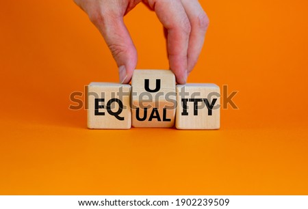 Equality or equity symbol. Businessman turns a cube and changs the word 'equality' to 'equity'. Beautiful orange background. Psychology, business and equality or equity concept. Copy space. Royalty-Free Stock Photo #1902239509