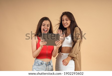 Two cheerful women waving on video call
