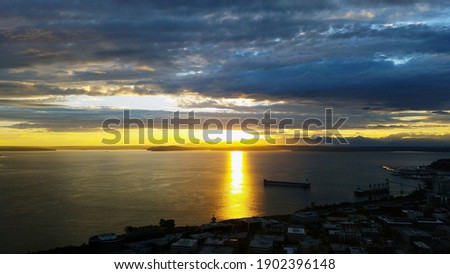 Bright yellow sunset with dark blue clouds over the ocean viewed from the Space Needle in Seattle Washington 