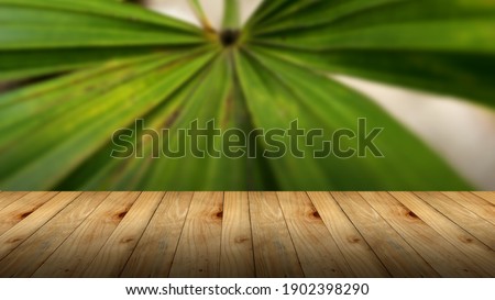 Wooden top table with bokeh light effect and blur outdoor park with green leaf on background, blur background