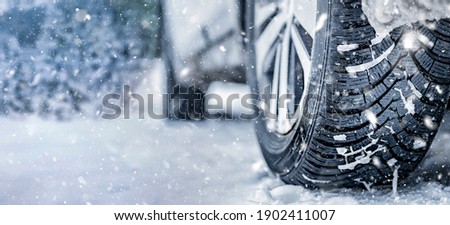 Winter tire. Detail of car tires in winter on the road covered with snow. Panorama, banner
