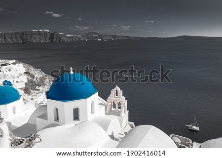 Selective color image, blue color with black and white process. Oia view in Santorini, caldera and blue church dome. Idyllic, inspirational travel landscape, famous destination scenic fine art banner