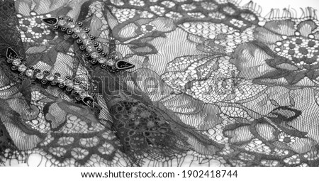 Black lace fabric on a white background. Fancy African tulle lace fabric polyester with full length flowers for your design. The texture. Background. Pattern