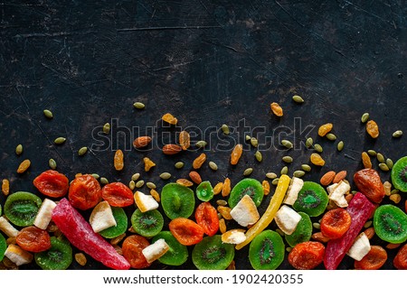 Composition of multicolored candied fruit on a dark background. View from above. A place for text.