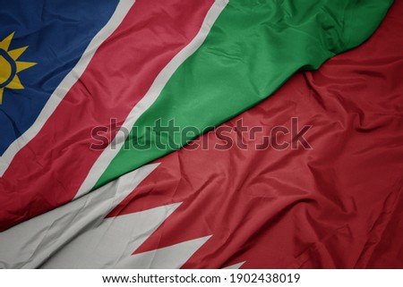 waving colorful flag of bahrain and national flag of namibia. macro