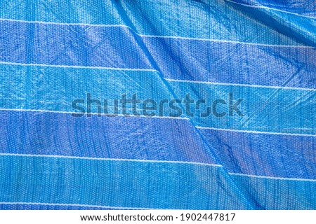 Blue Tarpaulin In Strong Sunlight. Stock Photo. Backgrounds.