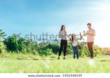 Happy asian family in the garden They are having fun playing and blowing bubbles. Royalty-Free Stock Photo #1902448549