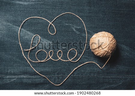 Love word and Heart from Wool Thread on Jeans Denim Background. Valentine's Day and Love concept photo.
