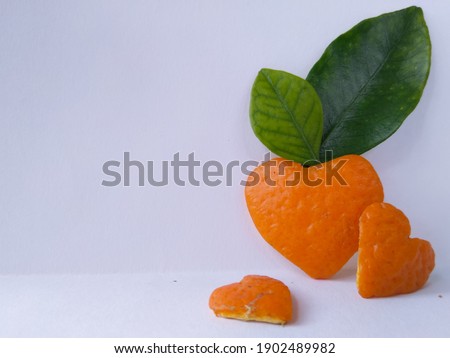 Orange peel in heart shape with leaves. Top view shot. Best used for brochure, website background, posters, greeting cards etc. Picture specifically for health conscious events and celebrations.