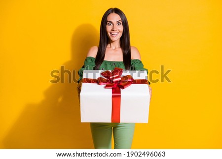 Photo portrait of shocked woman receiving white wrapped gift box isolated on vivid yellow colored background
