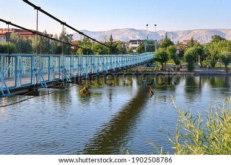  Beautiful steel bridge over the Kizilirmak River in Avanos Town, Turkey. View of the river and old city with a mosque in Avanos, central Anatolia Royalty-Free Stock Photo #1902508786